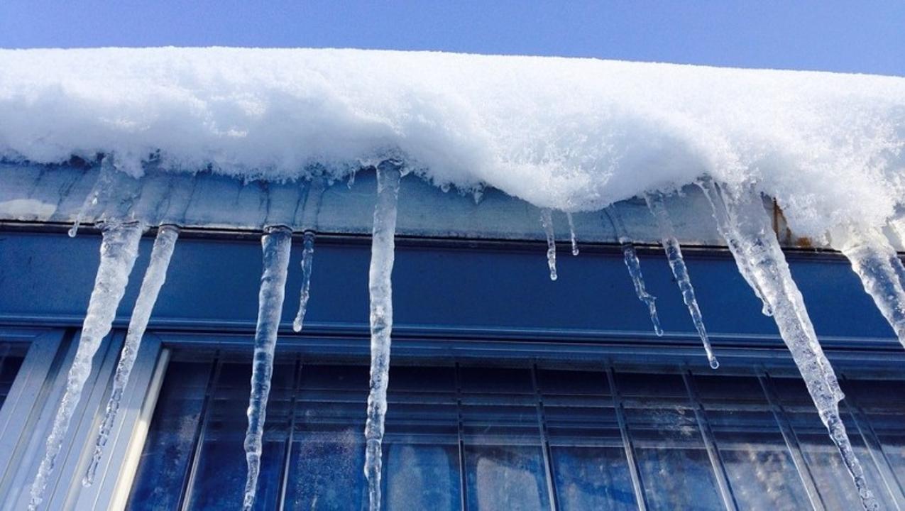 Жителей столицы предупредили об опасности сосулек и снега на крышах